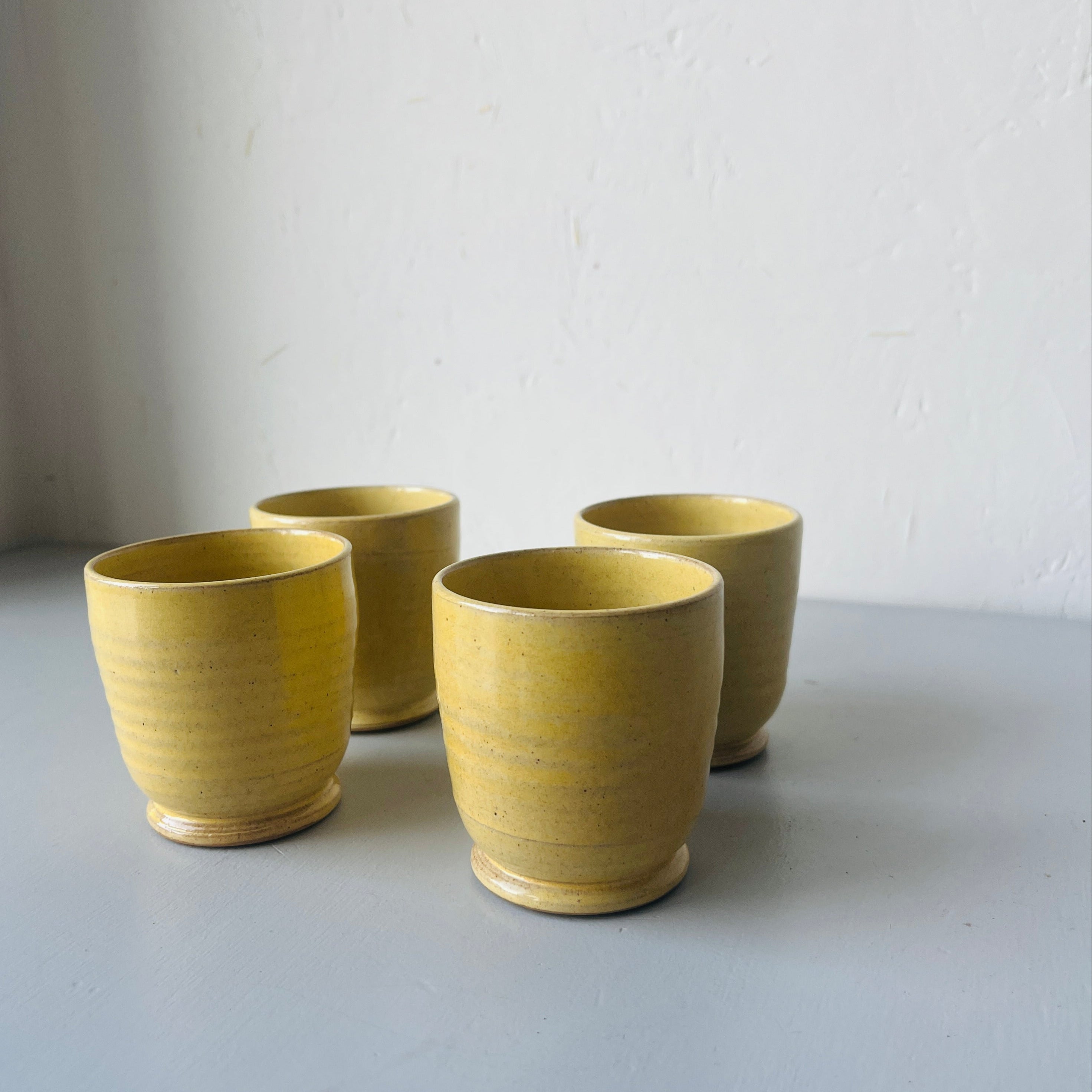 Set of 4 handmade ceramic butter yellow cups